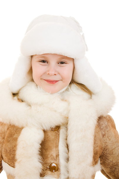 A girl in a fur coat and hat smiling on white background. - Valokuva, kuva