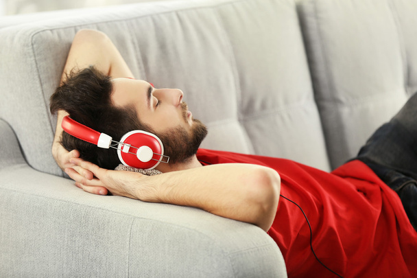 Young man listens music with headphones  - Фото, изображение