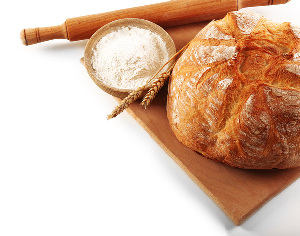 Bread with flour and ears on cutting board isolated on white - Фото, зображення