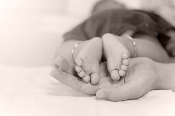 Pieds de bébé sur la main des mères
 - Photo, image