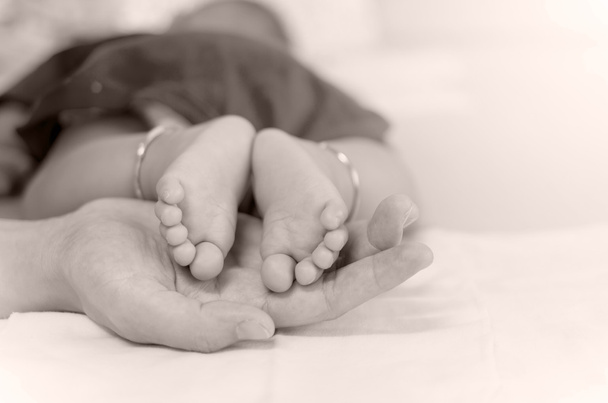 Babyfüße auf der Hand der Mutter - Foto, Bild