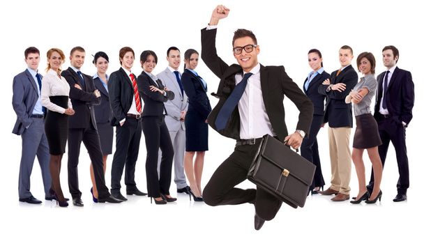Business man holding briefcase jumping in front of his team - Foto, Bild