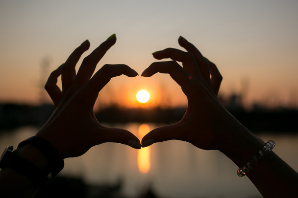 Herz aus Händen, im Sonnenuntergang - Foto, Bild