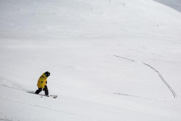 Ihminen lumilautailee lumessa vuorilla
 - Valokuva, kuva