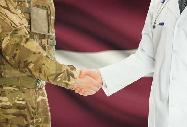 homme militaire en uniforme et le médecin se serrant la main avec le drapeau national sur le fond - Lettonie - Photo, image