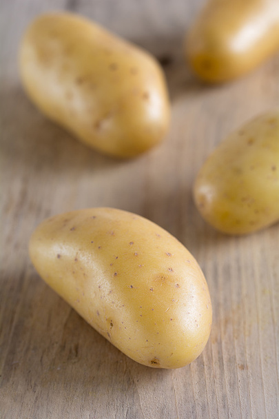 Сырой картофель лежит на доске
 - Фото, изображение