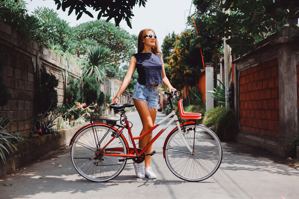 девушка позирует с винтажным велосипедом
 - Фото, изображение