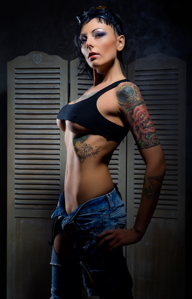 Beautiful woman with many tattoos posing indoors - Foto, imagen