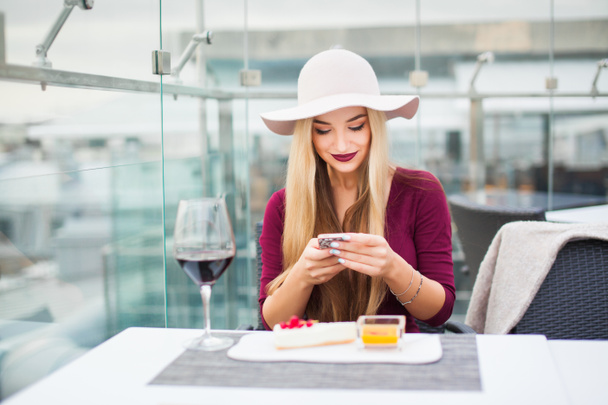 Frau trinkt Rotwein mit Handy - Foto, Bild