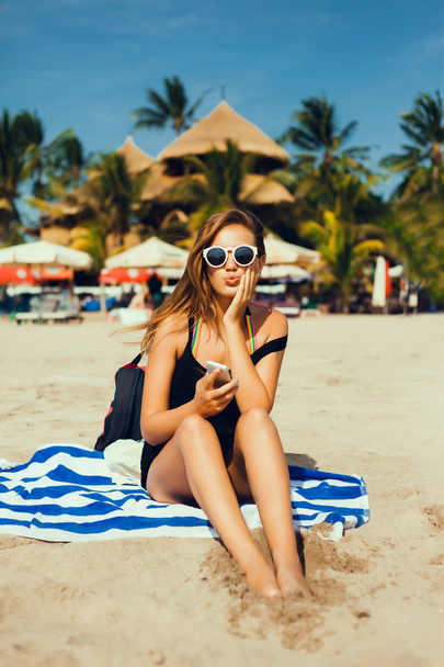 woman  on the beach with phone. - Фото, зображення