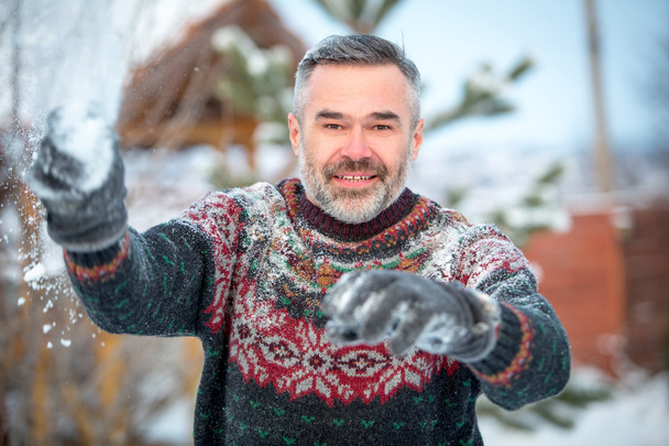 Winter fun man happy smiling and throwing snowballs - Foto, Imagem