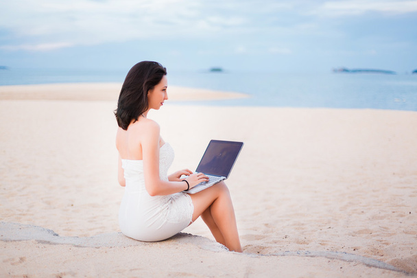 дівчина працює на ноутбуці на пляжі
 - Фото, зображення