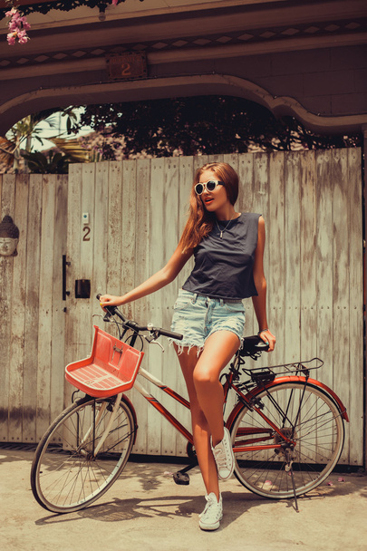 Tyttö poseeraa vintage polkupyörän kanssa
 - Valokuva, kuva