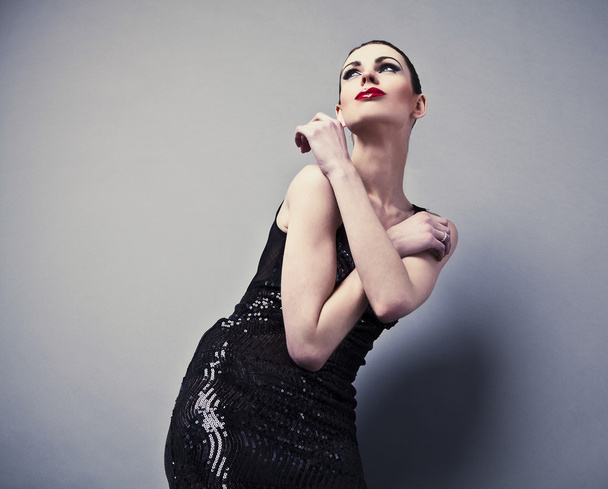 Beautiful woman on black classical dress pose in studio. - Фото, изображение