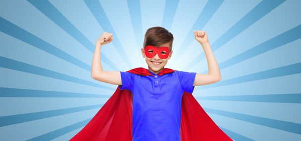 Junge in rotem Superhelden-Umhang und Maske mit Fäusten - Foto, Bild