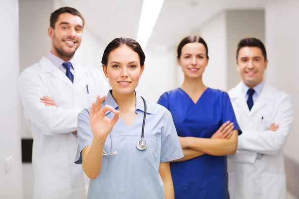group of medics at hospital showing ok hand sign - Foto, Imagen