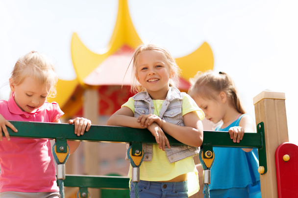 happy little girls on children playground - Foto, afbeelding