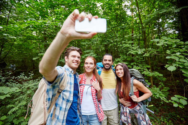 friends with backpack taking selfie by smartphone - Фото, зображення