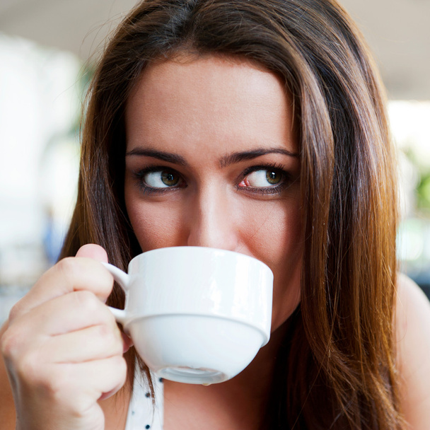 Closeup portrait of a pretty young female having a cup of coffee - Zdjęcie, obraz
