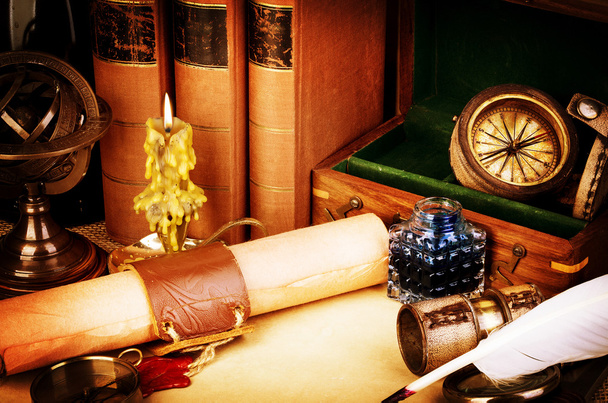 Old books, burning candle, spyglass, old scroll with red wax seal, vintage compass. Adventure stories background. Retro style. - Photo, Image