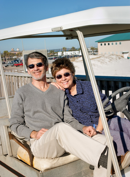 Couple retraité dans une vieille voiturette de golf à la plage
 - Photo, image