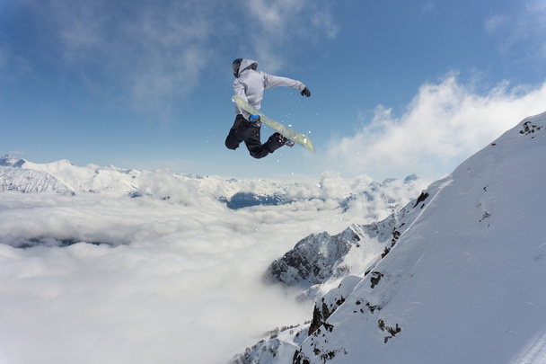 Flying snowboarder on mountains. Extreme sport. - Foto, afbeelding