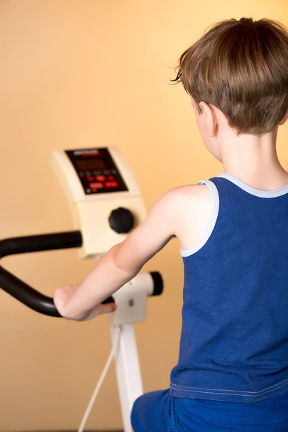 The child is trained on a stationary bike . Healthy lifestyle. - Photo, Image