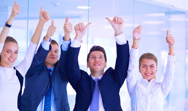 Feliz equipo de negocios mostrando pulgares hacia arriba en la oficina
 - Foto, Imagen