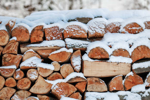 Stacked firewood and covered with snow - Fotó, kép