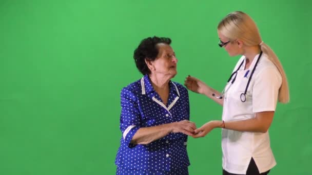 junge attraktive Krankenschwester hält alte Dame Hand. - Filmmaterial, Video