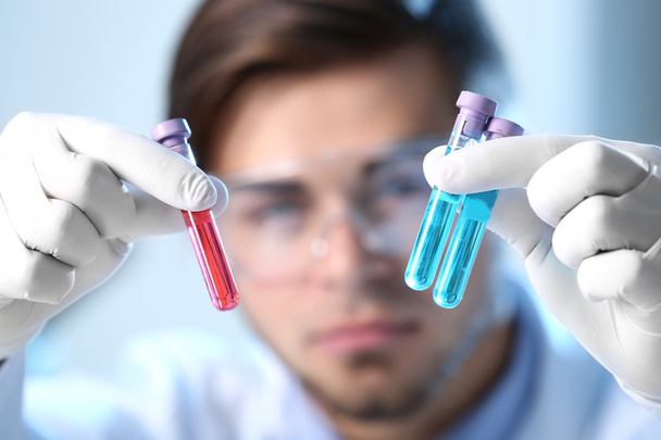 Man in laboratory checking test tubes - Фото, зображення