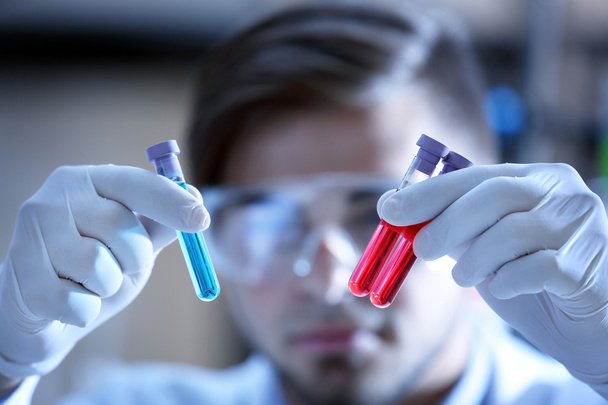 Man in laboratory checking test tubes - Foto, afbeelding