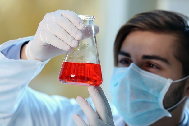 Mann im Labor kontrolliert Reagenzgläser - Foto, Bild