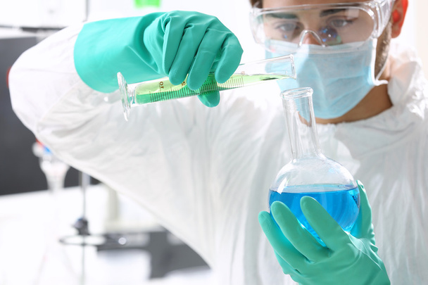 Man in laboratory checking test tubes - Fotó, kép