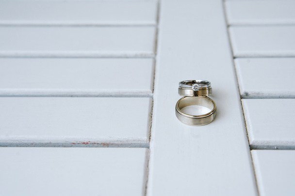 Wedding rings on white wooden background - Foto, afbeelding