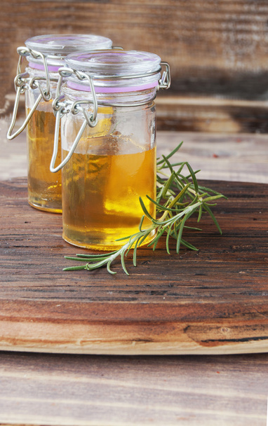 two jars of honey with rosemary - Фото, зображення