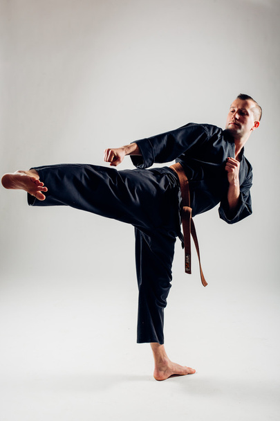 Joven macho con cinturón naranja entrenamiento de combate de karate
. - Foto, imagen