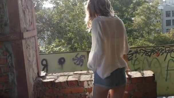 Model dívka pózuje na kameře procházce troskách opuštěné budovy. - Záběry, video