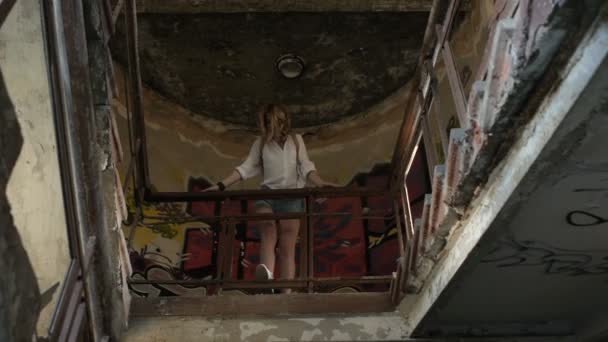 放棄された建物の遺跡を歩いてカメラのポーズの女の子モデル. - 映像、動画