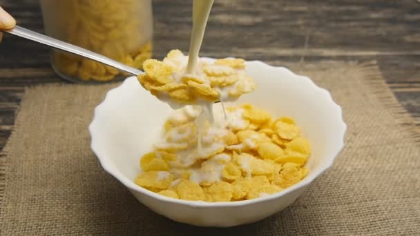 leche fresca vertiendo en un tazón lleno de copos de maíz en cámara lenta
 - Metraje, vídeo