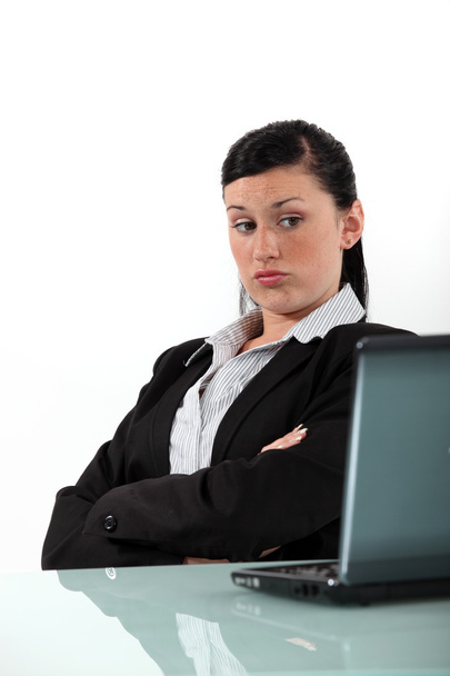 Bored businesswoman looking at her laptop - Photo, image