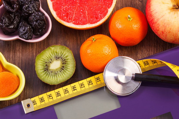 Electronic bathroom scale, centimeter and stethoscope, healthy food, slimming and healthy lifestyles concept - 写真・画像