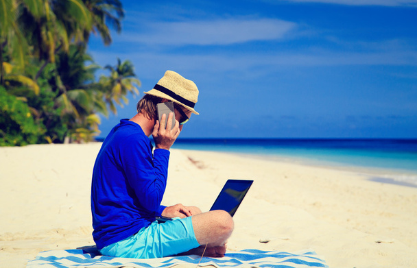 man with laptop and mobile phone on tropical beach - Photo, Image