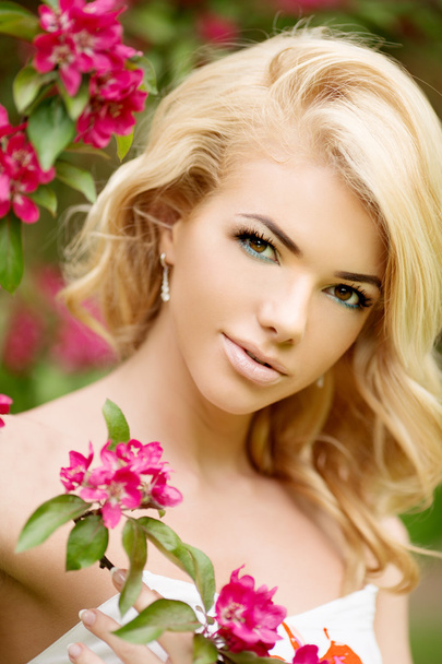 Young spring fashion woman. Trendy girl in the flowering trees - Photo, image