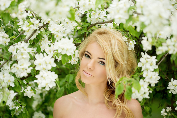 junge Frühlingsmode Frau. trendiges Mädchen in den blühenden Bäumen - Foto, Bild