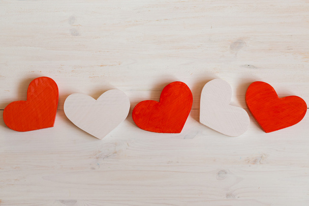 Red and white hearts on white wooden background - Photo, image