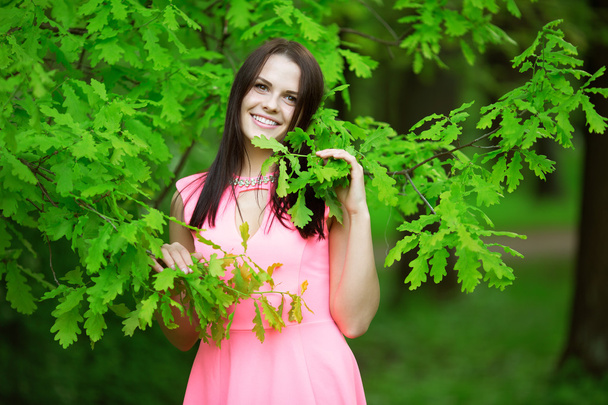 Young spring fashion woman. Trendy girl in the flowering trees i - Фото, зображення