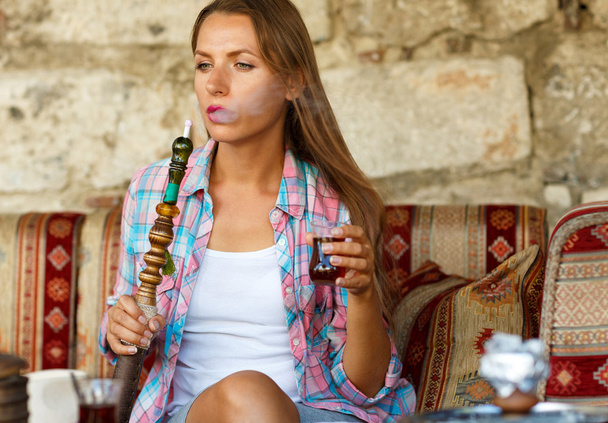Frau raucht Wasserpfeife und trinkt Tee im Café, istanbul, tur - Foto, Bild
