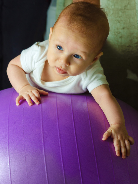Bambino ragazzo si sta esercitando sulla palla ginnica
 - Foto, immagini