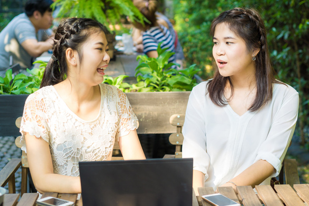 Due asiatiche giovani amiche usano internet insieme
 - Foto, immagini